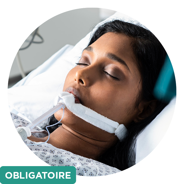 Une patiente, dont on voit les épaules et le visage, intubée à l’hôpital, et une zone de texte verte indiquant « obligatoire »