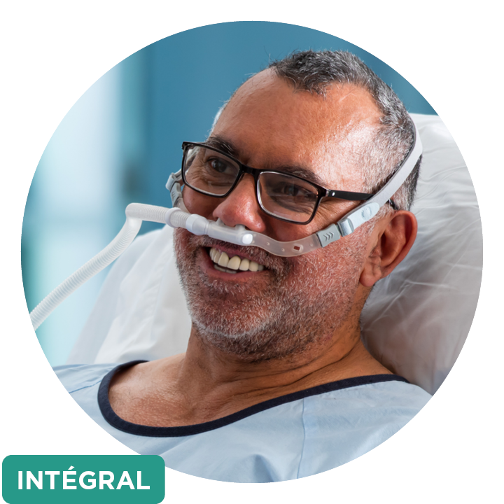 Un patient à l’hôpital portant une interface Optiflow™ ainsi qu’une zone de texte verte indiquant « intégral »