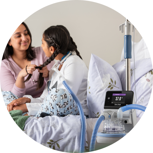 Adult being mechanically ventilated via a tracheostomy at home with an F&P my820 Respiratory Humidifier